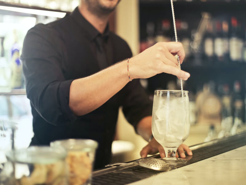 Bartender stirring a drink with ice at a cocktail making class